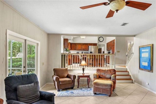 living room with a textured ceiling, ornamental molding, and light tile patterned flooring