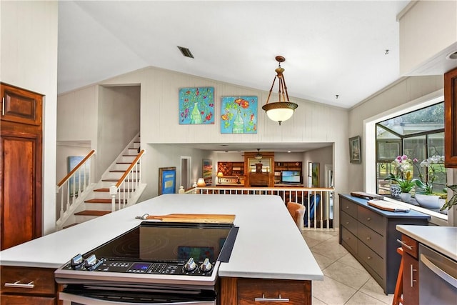 kitchen featuring a center island, stove, lofted ceiling, hanging light fixtures, and light tile patterned flooring