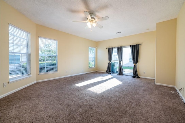 carpeted empty room with ceiling fan and a textured ceiling