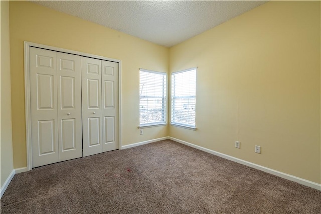 unfurnished bedroom featuring a closet, carpet flooring, and a textured ceiling