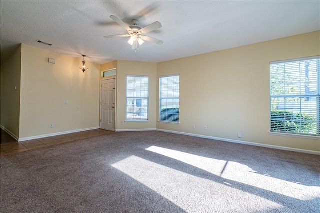 carpeted empty room with ceiling fan and a textured ceiling