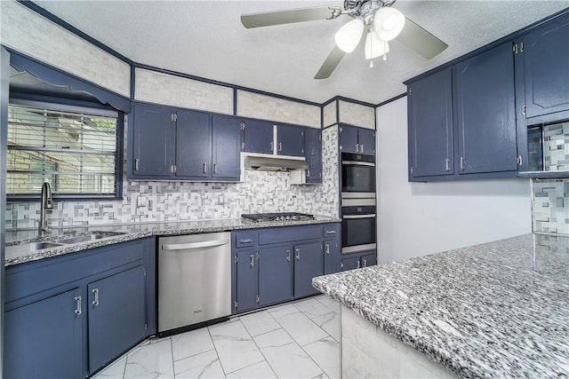 1501 Charles St, Waycross, GA 31501 - kitchen featuring appliances with stainless steel finishes, under cabinet range hood, ceiling fan, light marble finish flooring, and blue cabinets