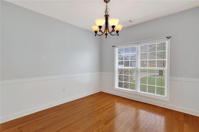 129 Taylor Wells Ln, Hinesville, GA 31313 - empty room featuring a wainscoted wall, a notable chandelier, hardwood / wood-style flooring, and visible vents