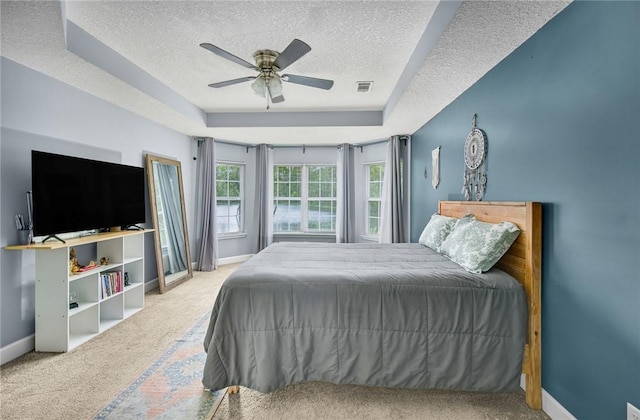 326 Daniel Trent Way, Kingsland, GA 31548 - carpeted bedroom featuring a textured ceiling, a tray ceiling, baseboards, and a ceiling fan