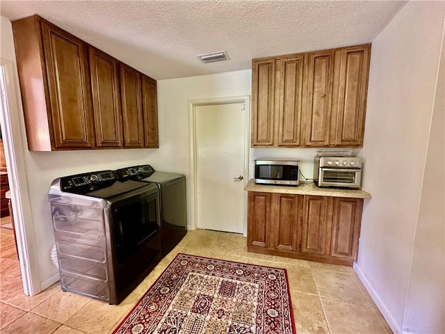 laundry room with separate washer and dryer, laundry area, a toaster, a textured ceiling, and visible vents