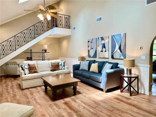living room with visible vents, wood finished floors, and arched walkways