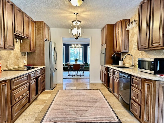 kitchen featuring light countertops, decorative backsplash, black appliances, and a sink