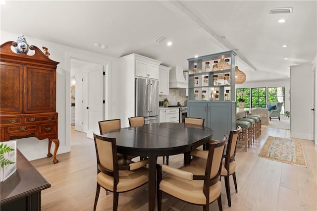 dining area featuring light wood finished floors, lofted ceiling, recessed lighting, visible vents, and baseboards