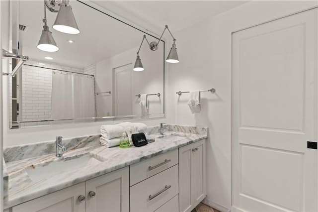 bathroom with a shower with curtain, visible vents, a sink, and double vanity