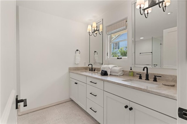 full bath featuring a chandelier, double vanity, tile patterned flooring, and a sink