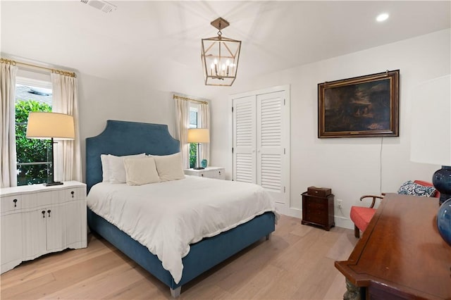 bedroom featuring visible vents, an inviting chandelier, light wood-type flooring, a closet, and recessed lighting