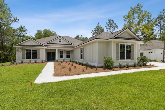 180 Ossabaw Way, Waverly, GA 31565 - view of front of property with a front yard, board and batten siding, and roof with shingles
