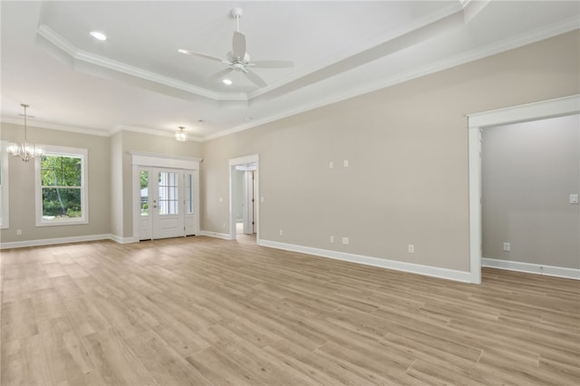 180 Ossabaw Way, Waverly, GA 31565 - unfurnished living room with a tray ceiling, a ceiling fan, light wood-type flooring, crown molding, and a chandelier