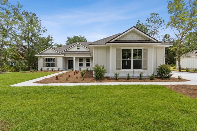 180 Ossabaw Way, Waverly, GA 31565 - view of front of home with board and batten siding, a front yard, and a shingled roof