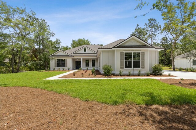 180 Ossabaw Way, Waverly, GA 31565 - back of property with board and batten siding and a lawn