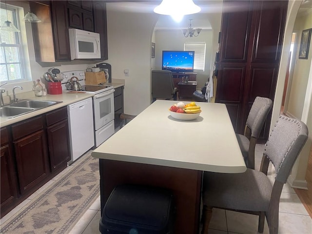 kitchen featuring sink, white appliances, a kitchen breakfast bar, and a center island