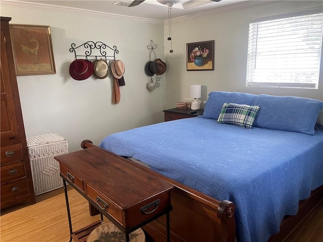 bedroom featuring crown molding, wood-type flooring, and ceiling fan