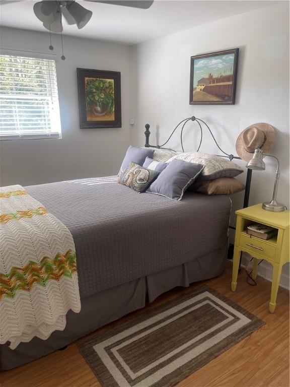 bedroom with ceiling fan and wood-type flooring