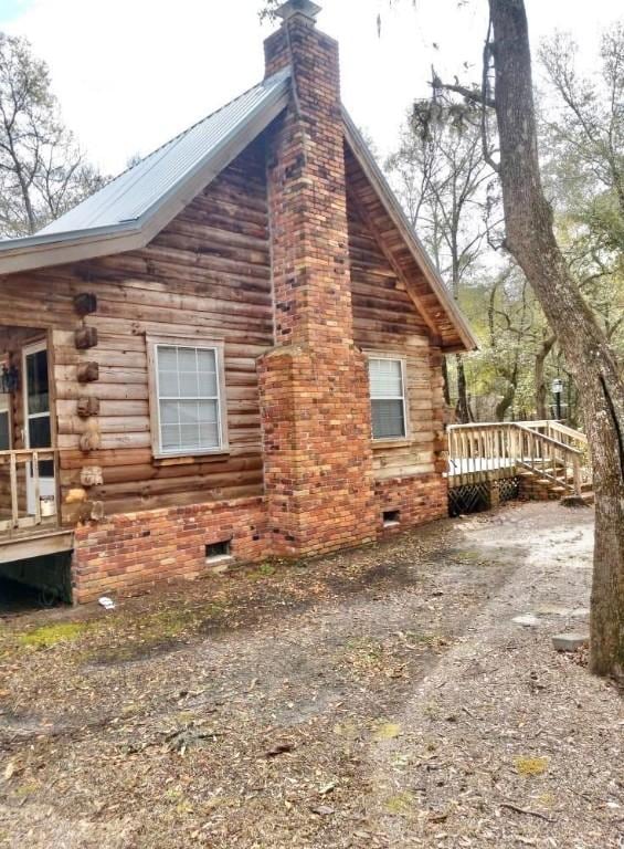 1518 To Jones Rd, Reidsville, GA 30453 - view of property exterior with a chimney, a wooden deck, log exterior, and crawl space