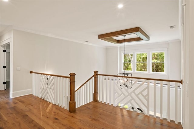 1241 Pikes Bluff Rd, Saint Simons Island, GA 31522 - hall featuring an upstairs landing, wood finished floors, a chandelier, crown molding, and a raised ceiling