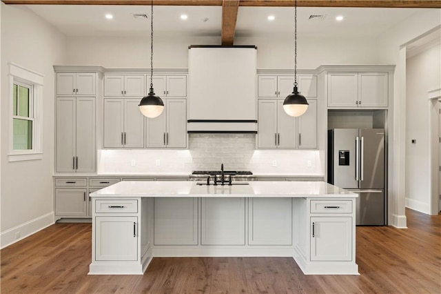 1241 Pikes Bluff Rd, Saint Simons Island, GA 31522 - kitchen with stainless steel refrigerator with ice dispenser, light countertops, a kitchen island with sink, recessed lighting, and wood finished floors