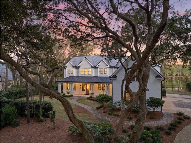 1241 Pikes Bluff Rd, Saint Simons Island, GA 31522 - view of front of house with covered porch, a metal roof, and brick siding