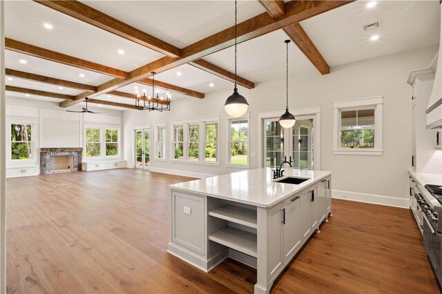 1241 Pikes Bluff Rd, Saint Simons Island, GA 31522 - kitchen featuring open shelves, hanging light fixtures, beam ceiling, wood finished floors, and a chandelier