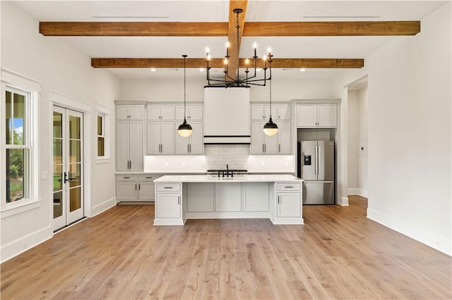 1241 Pikes Bluff Rd, Saint Simons Island, GA 31522 - kitchen with stainless steel refrigerator with ice dispenser, light countertops, decorative backsplash, a chandelier, and a kitchen island with sink