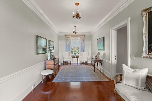 living area featuring dark hardwood / wood-style floors, crown molding, and an inviting chandelier