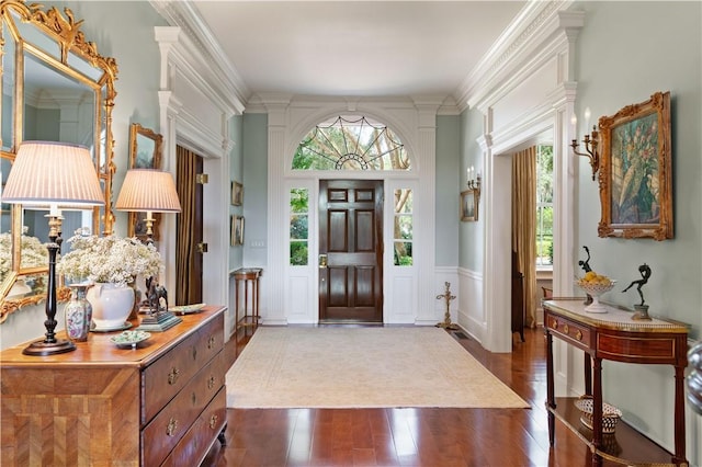 entrance foyer with dark hardwood / wood-style flooring, crown molding, and plenty of natural light