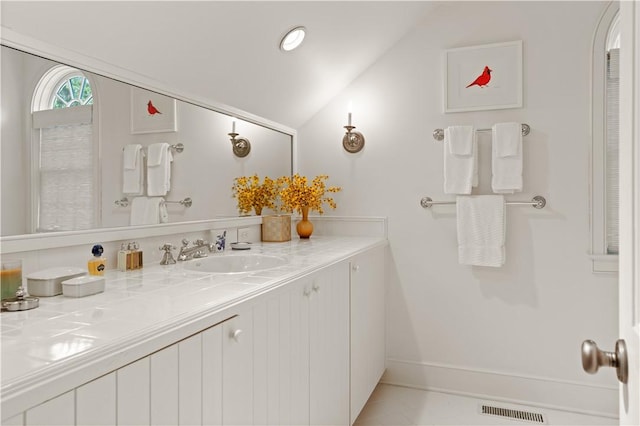 bathroom with vanity and lofted ceiling