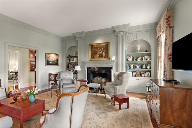 living area featuring built in shelves, crown molding, and light hardwood / wood-style flooring