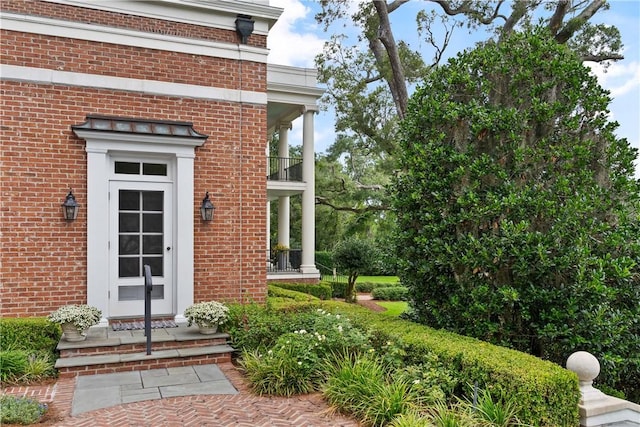 view of exterior entry featuring a balcony