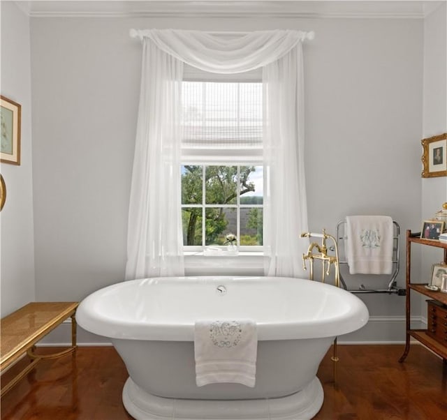 bathroom featuring a tub to relax in and ornamental molding