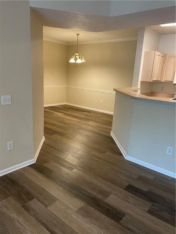 unfurnished dining area with dark hardwood / wood-style flooring, an inviting chandelier, and crown molding