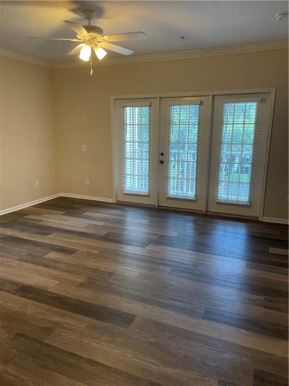 unfurnished room featuring french doors, dark hardwood / wood-style flooring, ornamental molding, and a healthy amount of sunlight