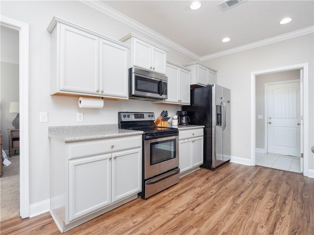 kitchen with white cabinetry, ornamental molding, stainless steel appliances, and light hardwood / wood-style flooring