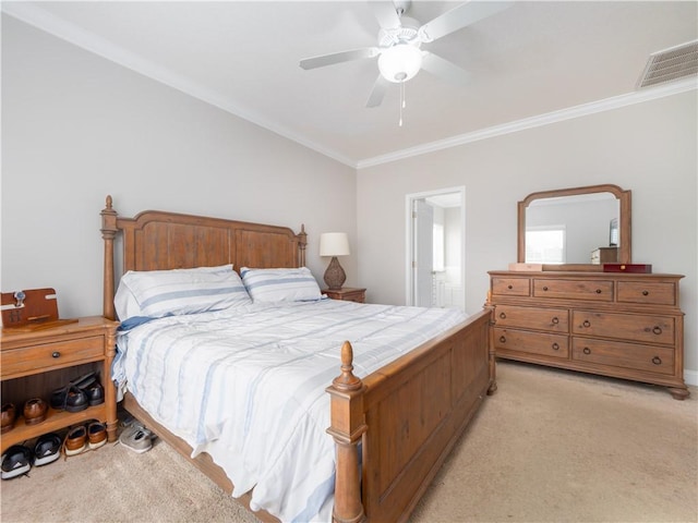 carpeted bedroom with ensuite bath, ornamental molding, and ceiling fan