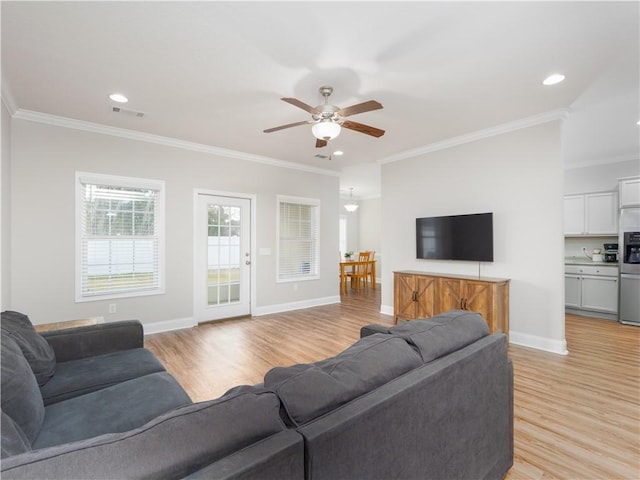 living room with light hardwood / wood-style flooring, ornamental molding, and ceiling fan