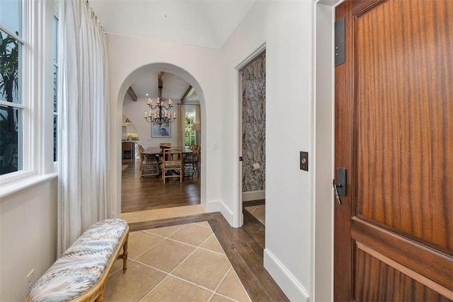 foyer entrance with elevator, an inviting chandelier, and hardwood / wood-style flooring