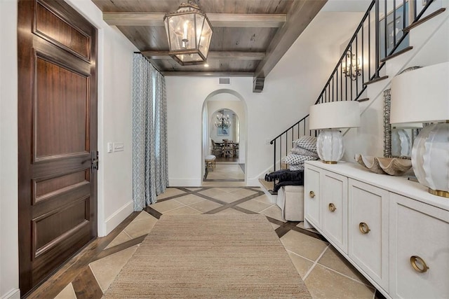 entrance foyer featuring beam ceiling, wood ceiling, and light tile patterned floors