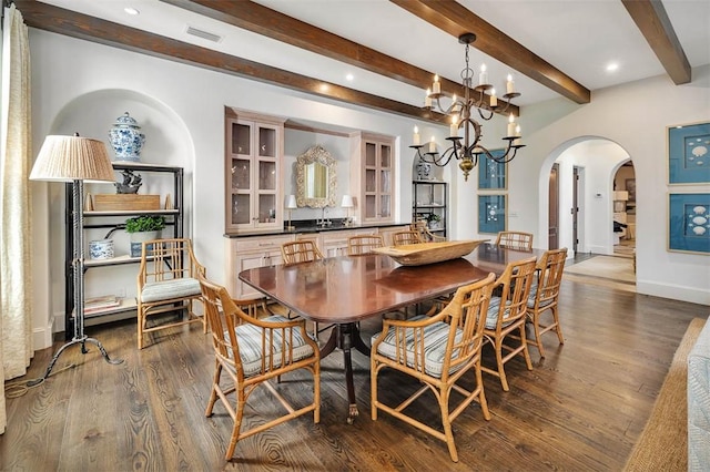 dining space with beamed ceiling, dark hardwood / wood-style floors, and a notable chandelier