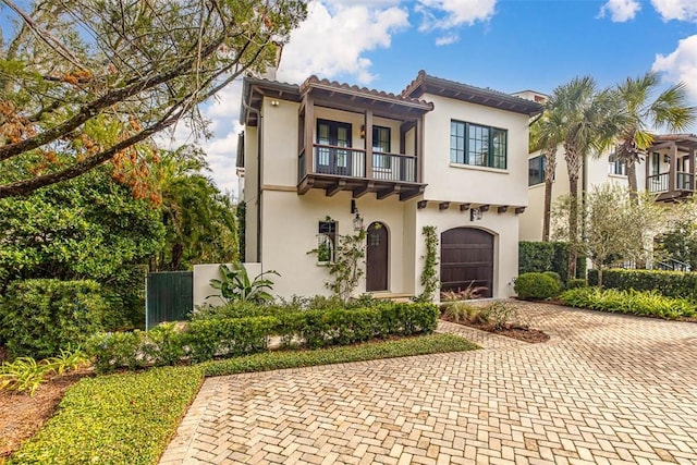 mediterranean / spanish-style home featuring a garage and a balcony