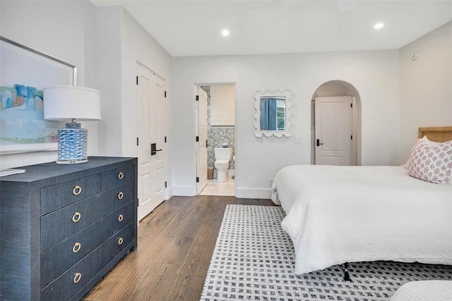 bedroom featuring dark hardwood / wood-style flooring and ensuite bathroom