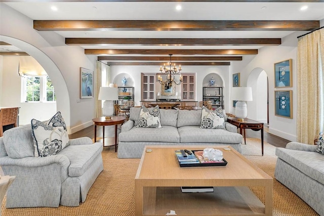 living room with beam ceiling, a chandelier, and light wood-type flooring