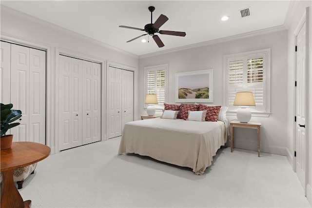 bedroom featuring recessed lighting, light colored carpet, visible vents, multiple closets, and ornamental molding