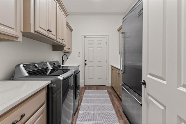 washroom with washing machine and dryer, dark wood-style flooring, cabinet space, and crown molding