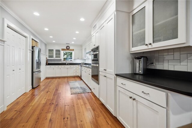 kitchen featuring white cabinetry, appliances with stainless steel finishes, sink, and light hardwood / wood-style floors