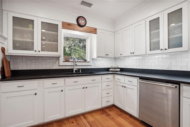 kitchen featuring dishwasher, white cabinets, and backsplash