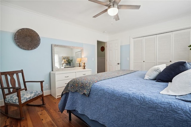 bedroom with dark wood-type flooring, ceiling fan, ornamental molding, and a closet